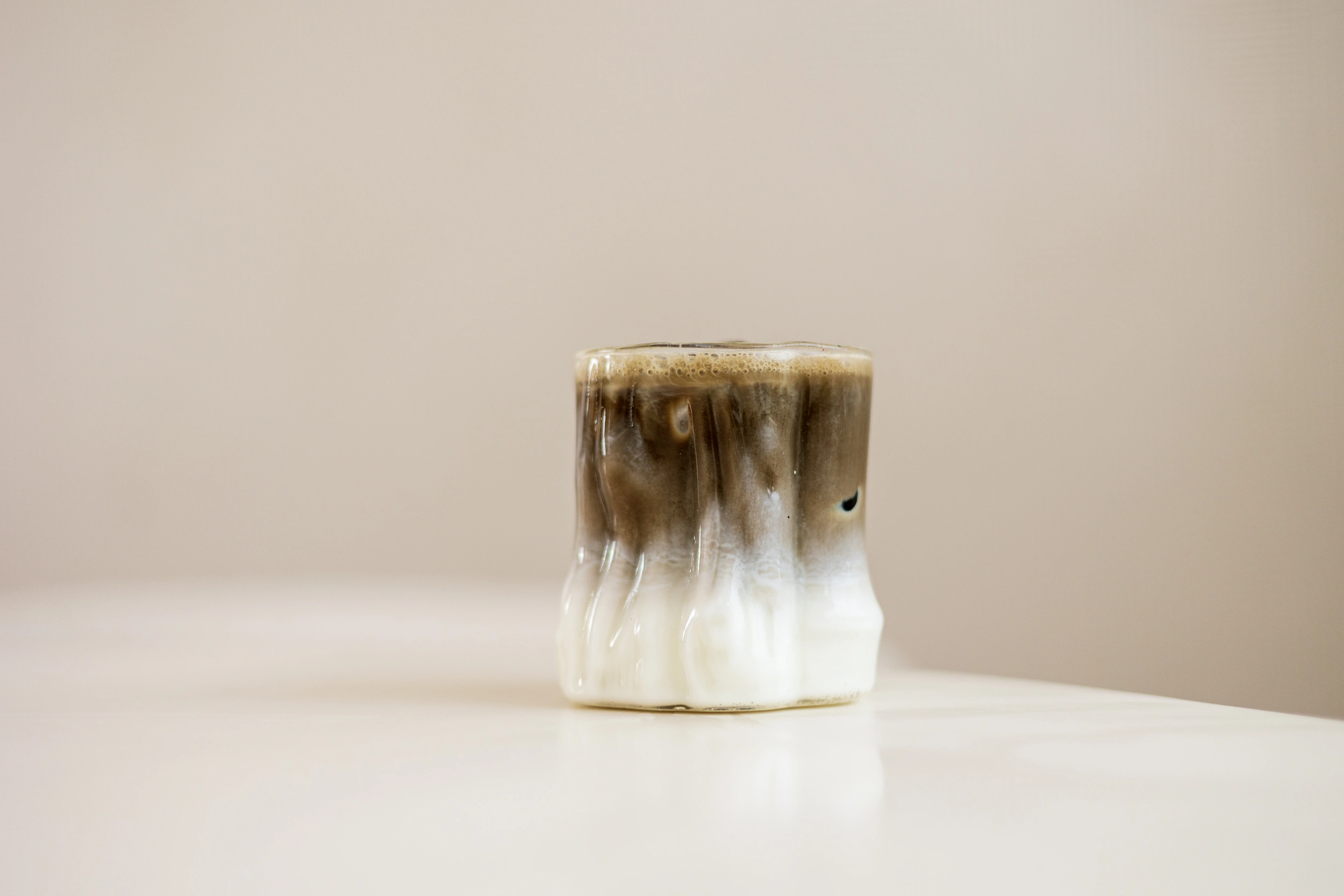 SHINYU Hojicha - large pack - 1 kilo 5 Handmade ceramic cup with a drip glaze in brown and white, filled with a frothy coffee drink