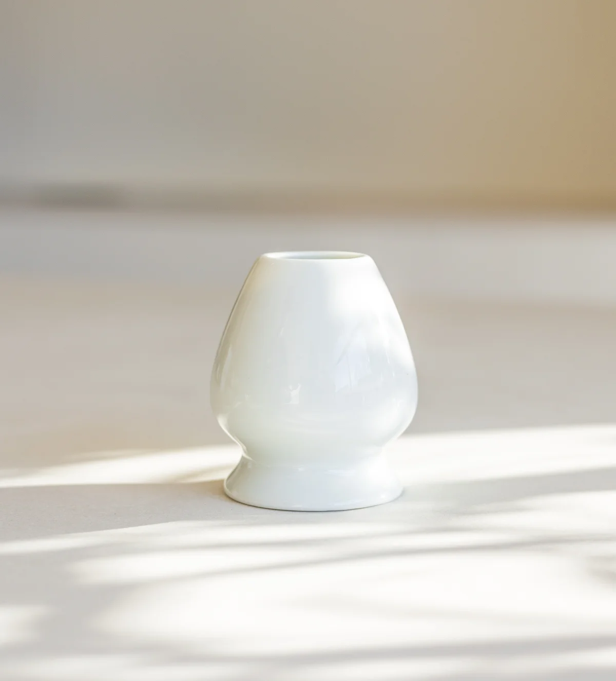SHINYU Matcha starter kit 4 Wit keramische matcha klopper houder met glanzend glazuur op een beige ondergrond