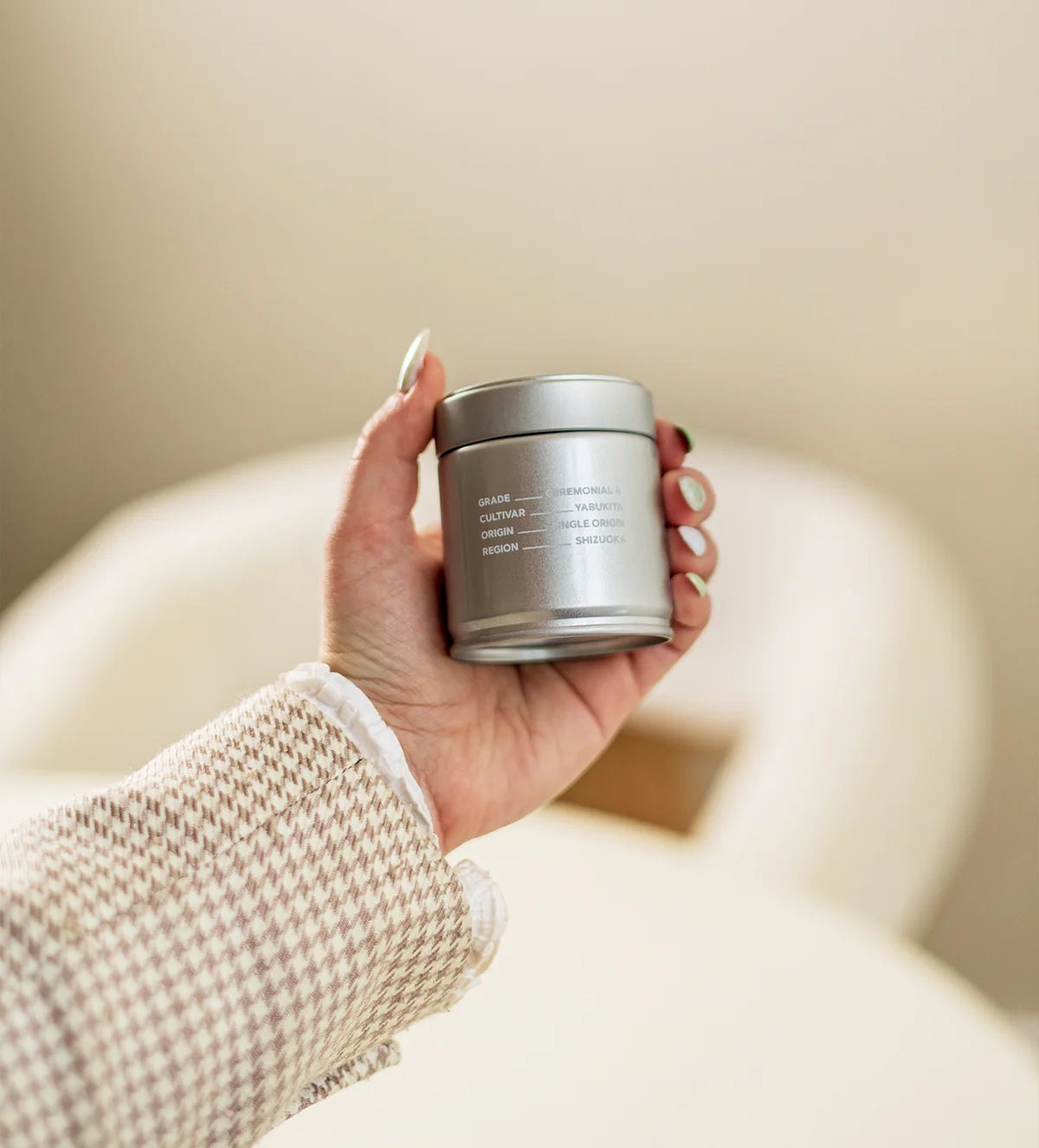 SHINYU Matcha - Bewaarblik 4 Hand houdt een zilveren matcha-blik vast met opschrift: Grade Ceremonial, Cultivar Yabukita, Origin Single Origin, Region Shi